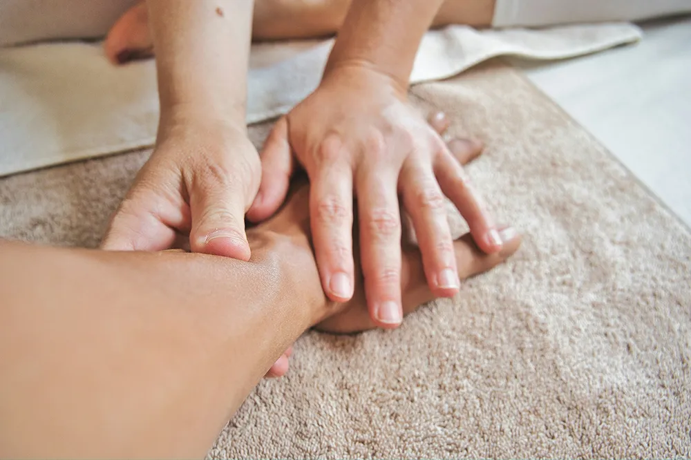 mains effectuant un massage lymphatique sur un bras