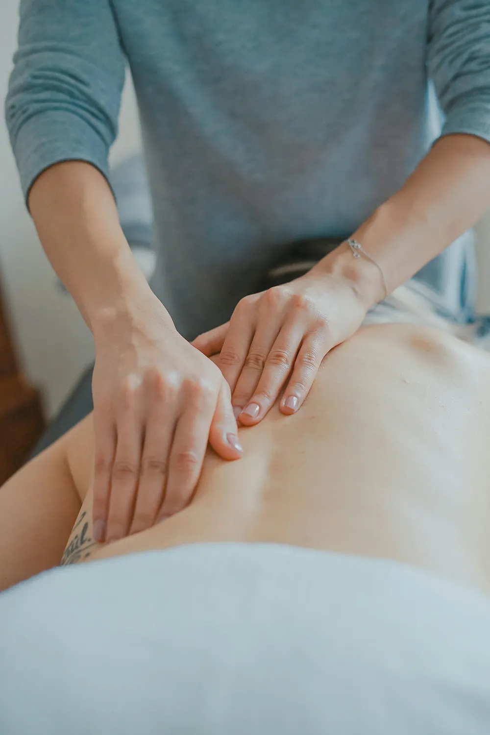 mains effectuant un massage thérapeutique sur un dos