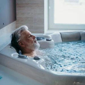Homme senior se relaxant dans un jacuzzi, illustrant la détente et le bien-être chez EV Clinic